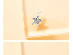 Macro shot of silver star-shaped pendant charm with inset clear rhinestones