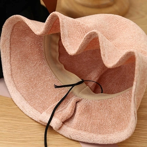 Detail view of pink knit bucket hat showing soft bouclé texture and inner adjustable cord