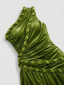 Detail of moss green velvet dress showing intricate twisted knot and pleated texture