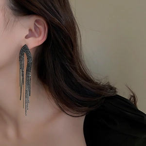 Close-up of black rhinestone tassel earrings worn by a model to show elegant drape