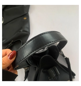 Detail of black punk style triangular bag handle with neat stitching and PU leather texture