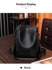 Detail shot of black pebbled leather backpack with metallic rivets on a vintage wood surface