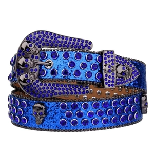 Blue rhinestone belt with skull metal studs and ornate buckle on white background