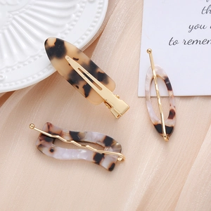Detail view of 3-piece tortoiseshell acetate hair clip set with golden alloy finish