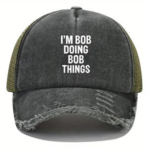 Macro detail of distressed washed denim visor and mesh on trucker cap with I'M BOB print