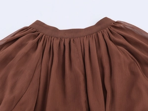 Close-up of brown pleated chiffon fabric showing soft textures and ruffled details