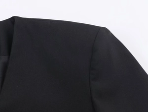 Dettaglio ravvicinato del rever e della cucitura della spalla di una tuta blazer nera