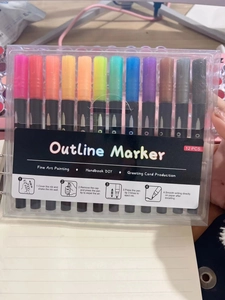 Detail of 12-color outline markers packaging showing the usage guide and vibrant pen colors