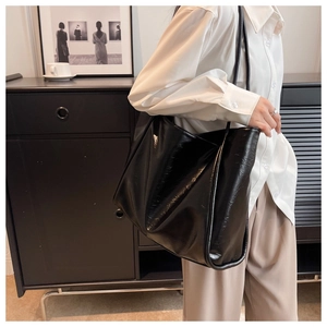 Vue portée d'un grand sac cabas noir en cuir au design minimaliste et élégant