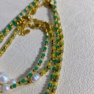 Detail einer Barockperlenkette mit grünen Kristallperlen und goldenem Karabiner
