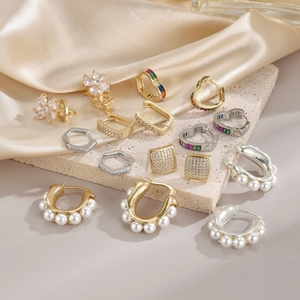 Elegant irregular pearl earrings and crystal jewelry collection on silk background