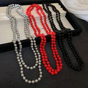 Elegant long faux pearl necklace in red black and silver on velvet jewelry tray
