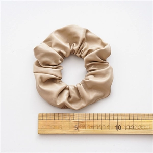 Minimalist beige PU leather scrunchie with 10cm diameter shown on a white background