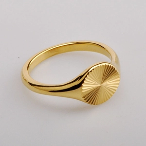 Close-up of a high-polished 18K gold plated ring with a sunburst texture design