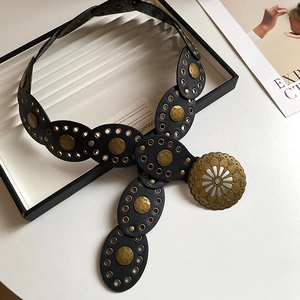 Detail of black leather waist chain with brass rivets and engraved hollow buckle