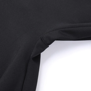 Dettaglio ravvicinato della cucitura sartoriale su tuta slim nera con gamba svasata