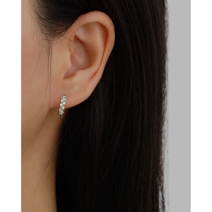 Close-up of s925 silver huggie earrings with double rows of clear sparkling stones