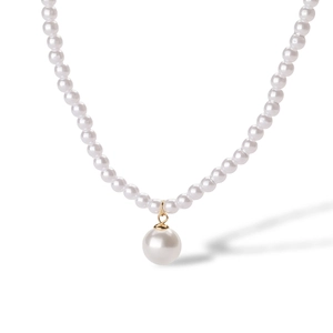 Detail of 18K gold ball pendant and teardrop pearl on a minimalist white pearl necklace