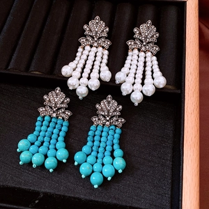 Détail de boucles d'oreilles vintage avec perles, perles turquoise et feuilles serties