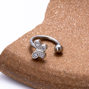 Silver butterfly labret stud with micro-paved zircons on a textured brown stone