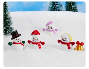 Gruppo di pupazzi di neve natalizi colorati in miniatura in una scena di neve reale