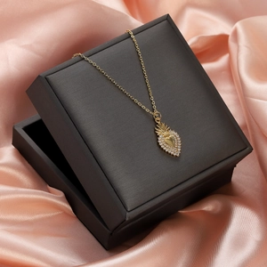 Close-up of a gold heart pendant with zircon crown in a premium black gift box