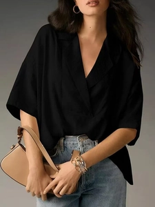 Short sleeve V-neck button down shirt in black styled with jeans and leather handbag