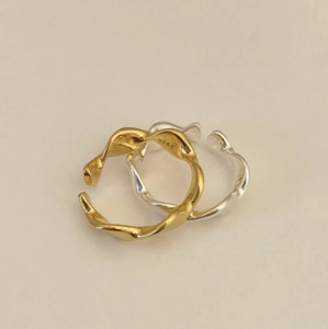 Minimalist geometric wave twisted open rings in gold and silver set on beige background