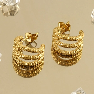 Chic U-shaped triple-layer hammered gold earrings on mirror background with ice cubes