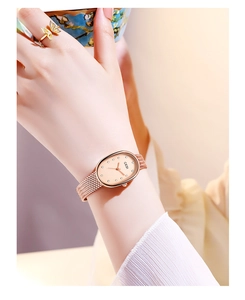 Close-up of rose gold oval watch with mother-of-pearl dial on woman's wrist
