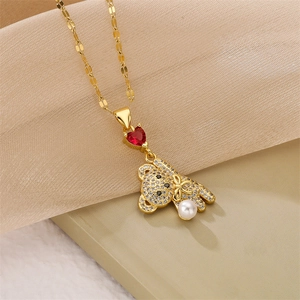 Detail of gold teddy bear pendant necklace with red heart zircon and white pearl