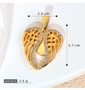 Detailed macro of golden heart angel wing pendant with white cubic zirconia micro-pave