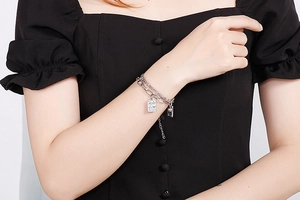 Close-up of double-layer stainless steel chain bracelet with poker card pendant on wrist