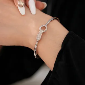 Silver plated cuff bracelet with pavé zircon keyhole pendant worn by a female model