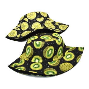 Gros plan détaillé des motifs citron et kiwi sur des chapeaux bobs en coton noir