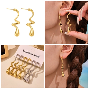 Gros plan sur les boucles d'oreilles vagues géométriques en acier inoxydable or et argent