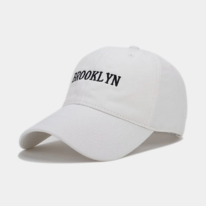 Detailed close-up of Brooklyn letter embroidery on a white cotton baseball cap