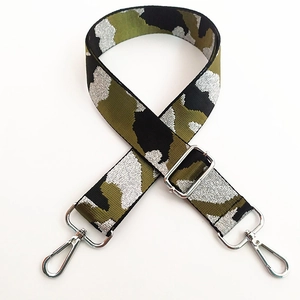 Detailed view of camouflage handbag strap with silver metallic thread and metal hooks