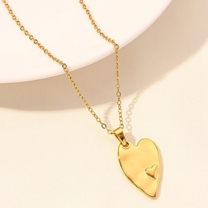Macro shot of gold double heart pendant necklace with irregular 18k plated finish