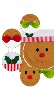 Detail of gingerbread man chair cover with festive green bow and holly leaf decoration