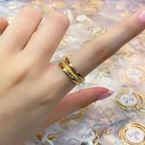 Stacked golden stainless steel rings for women displayed on finger with size labels