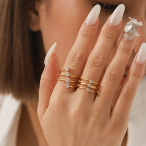 Detail eines dreilagigen goldenen Edelstahlrings mit funkelnden Zirkonia-Kristallen