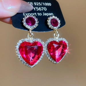 Détail de boucles d'oreilles cœur en cristal magenta avec argent 925 et accents diamant