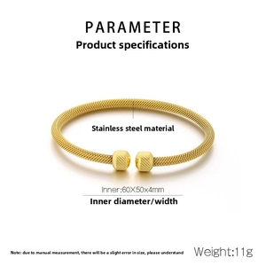Detail of gold woven mesh stainless steel open bangle with textured bead ends