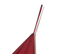 Detail of red satin dress shoulder strap connection and smooth fabric texture macro