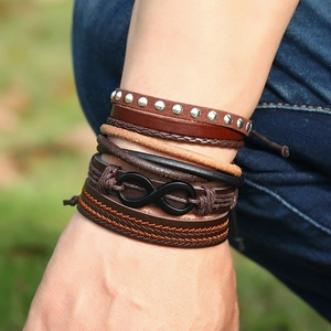 Detail of layered vintage leather bracelets with infinity charm and woven cords on wrist