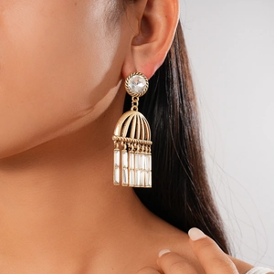 Macro side view of retro gold tassel earrings with zircon studs worn by a model
