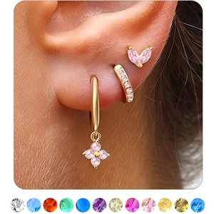 Close-up of three gold earrings with pink zircon on model including 12 birthstone colors