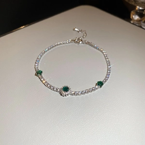 Vue macro détaillée du bracelet en argent avec des pierres d'émeraude verte étincelantes