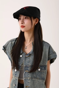 Détail de la casquette gavroche en coton noir avec broderie R rouge sur le dessus